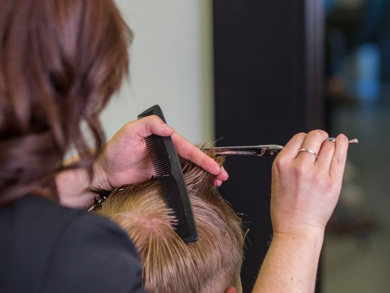 Detailansicht während Lilia Moser einem Herren die Haare schneidet
