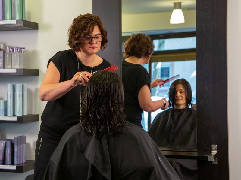 Inhaberberin und Master-Stylistin Nicole Jöst-Braun frisiert die langen Haare einer Kundin