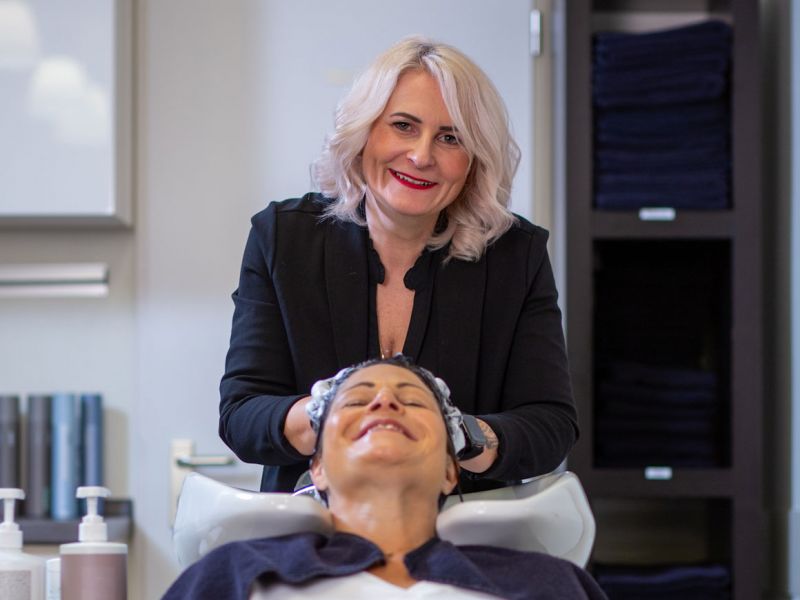 Andrea Berschet wäscht einer glücklichen Kundin die Haare